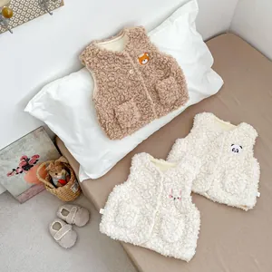 Détail de gilets en polaire pour bébé avec broderies animalières et boutons pression