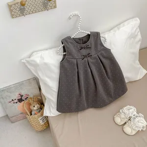 Detail of dark grey polka dot dress for girls featuring sweet bows and pleated skirt