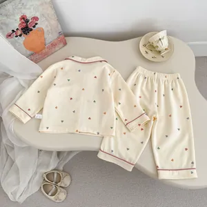 Detalle de pijama para niña con estampado de corazones, ribete rosa y encaje suave