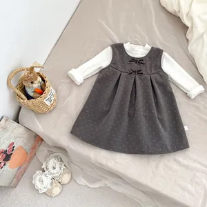 Close-up of toddler girls' dress set with grey polka dot dress and white turtleneck