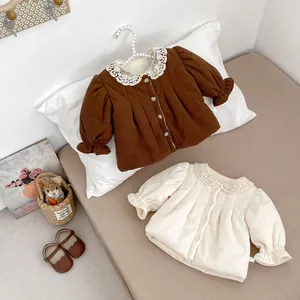 Close-up of velvet corduroy baby coats with lace collars and elasticated cuffs