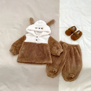 Flat lay of thick caramel fleece baby pajama set with 3D bear ears on hood