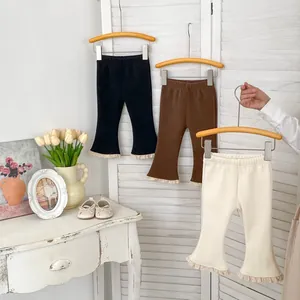 Dettaglio dei pantaloni svasati a costine per bambine con eleganti bordi in pizzo