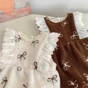 Detail of fleece baby rompers with lace sleeves and bow patterns in two colors