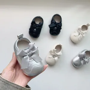 Détail de chaussures en velours pour bébé avec de grands nœuds en satin et velcro pratique