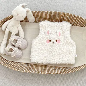 Détail du gilet en peluche pour bébé avec oreilles de lapin brodées sur polaire