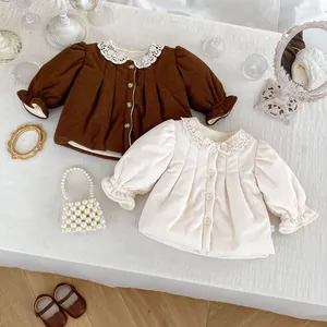 Flat lay of girl's corduroy jackets in brown and cream with delicate lace collars