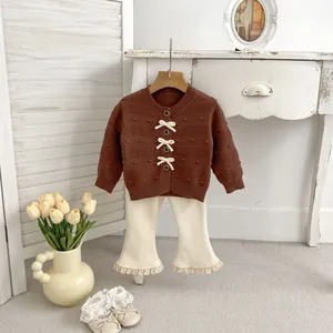 Detail von Baby-Mädchen Strickjacke mit Schleifen und Schlaghose mit Spitzenbesatz