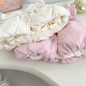 Detail of quilted toddler vests with soft fleece lining in beige and pink colors