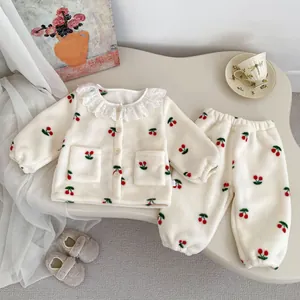 Detail van warme winter fleece pyjama voor meisjes met kersenborduurwerk en kanten kraag