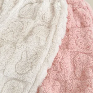 Détail du tissu polaire corail moelleux avec motifs de cœurs 3D en relief