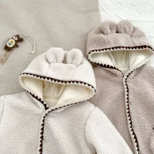 Detail von warmen Baby-Overalls aus Teddy-Fleece mit Bärenohren und geometrischem Rand