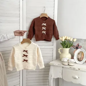 Detail der Baby-Strickjacke mit 3D-Schleifen und strukturiertem Polka-Dot-Muster