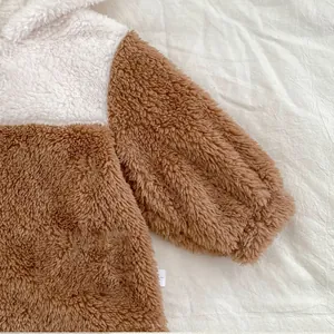 Detailed view of soft brown and white sherpa fleece fabric on baby winter pajamas