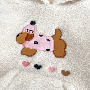 Dettaglio del ricamo a cucciolo su felpa in pile bianco per bambine inverno