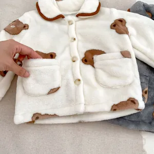 Détail d'un pyjama d'hiver pour bébé avec motif ours et texture en polaire douce