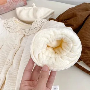 Detail of baby winter outfit showing plush lamb wool lining and lace collar texture
