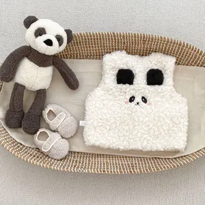 Détail du gilet en polaire panda pour bébé et des chaussons assortis