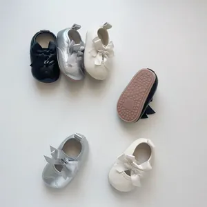 Vues détaillées du dessus et du dessous de chaussures de princesse bébé avec nœud papillon
