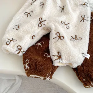 Detail view of thickened fleece baby jumpsuit featuring cute bow patterns and soft texture