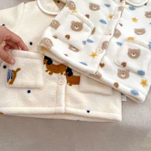 Detailopname van dikke fleece stof en schattige berenprint op wintervest voor jonge kinderen