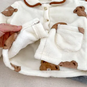 Détail du pyjama pour bébé en polaire blanche montrant la doublure douce et le motif ours