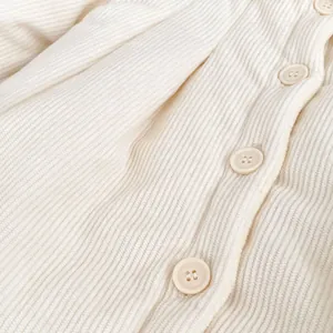 Detail of baby girl velvet winter coat with beige corduroy texture and button closure