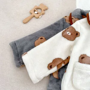 Détail du manteau d'hiver en polaire pour bébé avec motifs d'ours et texture douce
