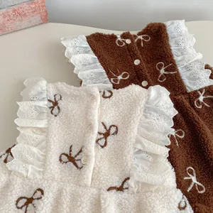 Detailed view of plush fleece baby vest with delicate bow embroidery and lace trim