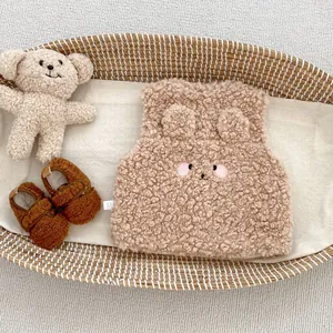 Détail du gilet bébé en polaire crème avec oreilles d'ours 3D et broderie mignonne