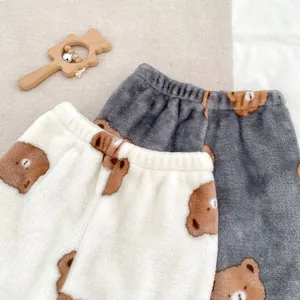 Détail de pantalons d'hiver en peluche pour bébé avec motifs ours et taille élastique