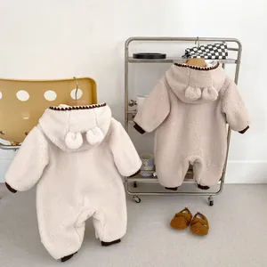 Detail eines Baby-Winter-Fleece-Einteilers mit süßer Ohrenkapuze und brauner Borte