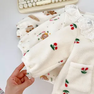 Detail van winterfleece tops voor baby's met kantkraag en schattige prints
