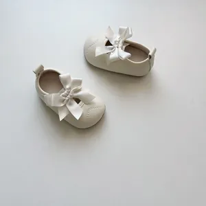 Vue détaillée de chaussures de marche pour bébé fille avec nœud crème et texture souple