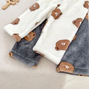 Détail du pantalon thermique en peluche avec motif d'ours et poignets élastiques