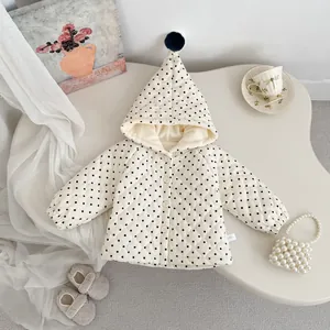 Detail of white quilted polka dot toddler hooded jacket with plush pom-pom and button front