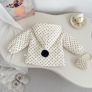 Detail view of quilted polka dot baby hoodie jacket with navy pom-pom and soft texture