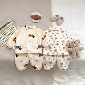 Detailopname van twee zachte fleece peuterpyjama's met schattige cartoon beer en hond patronen