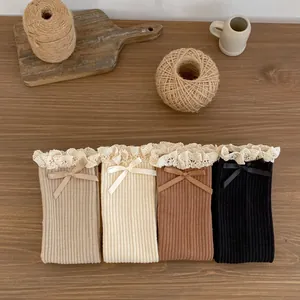 Detail of four pairs of vintage ribbed cotton socks with lace ruffles and satin bows