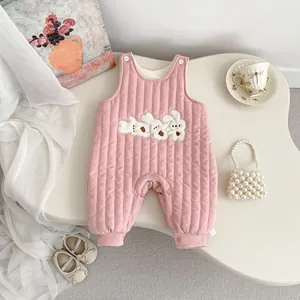 Close-up of pink quilted newborn jumpsuit with cute white rabbit embroidery details