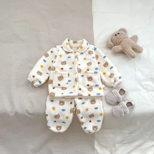 Detail van winterpyjama voor baby's met berenprint en zachte fleece stofstructuur