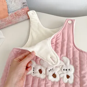 Pink quilted infant romper with rabbit embroidery and warm fleece lining shown in detail