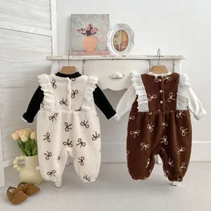 Detail of fleece baby rompers with bow prints and delicate lace ruffle shoulders