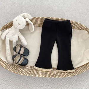 Close-up of children flared trousers featuring ribbed fabric and beige lace hem detailing