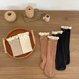 Detail of ribbed cotton socks featuring delicate lace edges and small silk bows