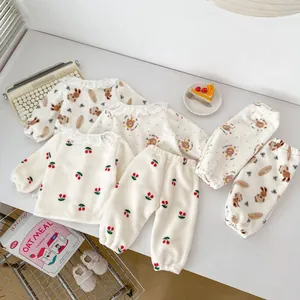 Detail van babyfleece pyjama's met kanten kragen en kersen- en beertjespatronen