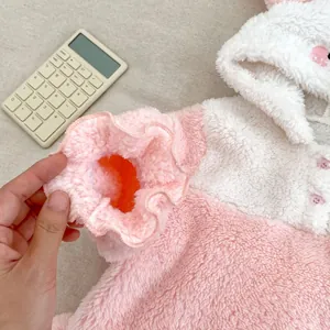 Detail of pink coral fleece baby pajamas sleeve with ruffled edges and soft texture