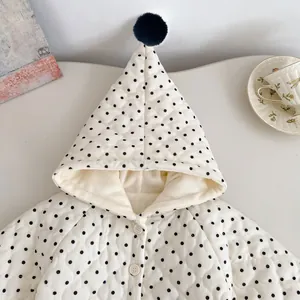 Detail of baby quilted jacket with black polka dots, pointed hood and fleece lining
