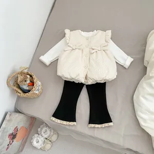 Detailed flat lay of toddler winter 3-piece set with quilted vest and lace-up flare pants
