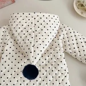 Detail of quilted corduroy baby jacket with polka dots and pom-pom hooded design